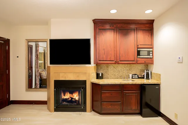 a kitchen with a fireplace and a television