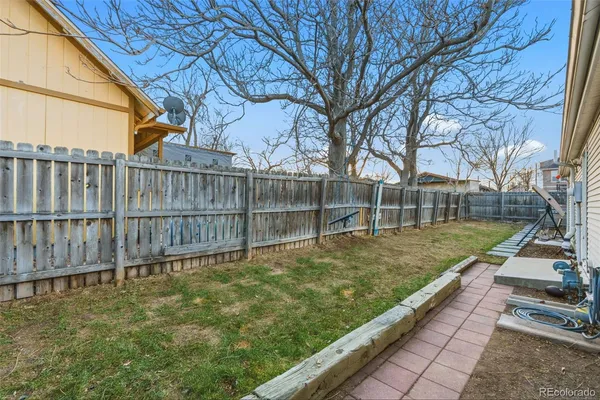 a view of a backyard with wooden fence