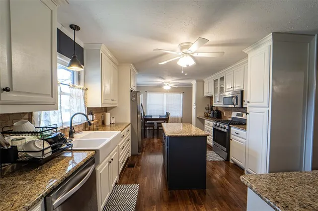 a kitchen with stainless steel appliances granite countertop a stove refrigerator sink and dishwasher