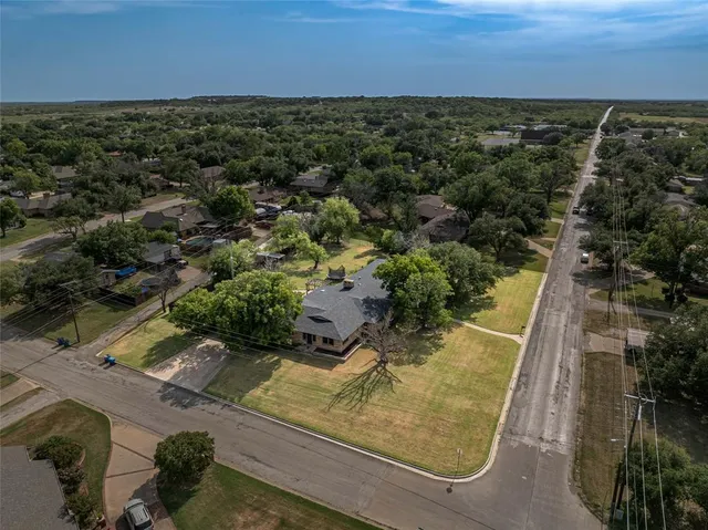 an aerial view of residential houses with outdoor space and trees