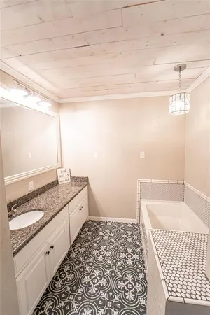 a bathroom with a granite countertop sink and a bathtub