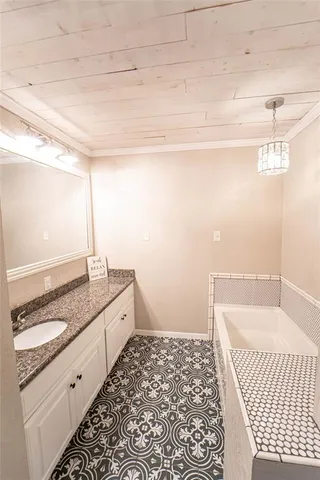a bathroom with a granite countertop sink and a bathtub