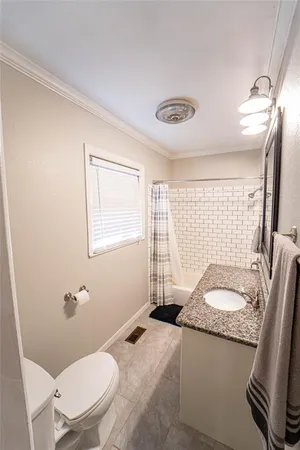 a bathroom with a granite countertop sink mirror vanity and toilet