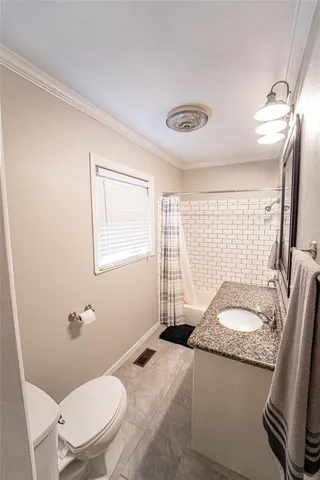 a bathroom with a granite countertop sink mirror vanity and toilet