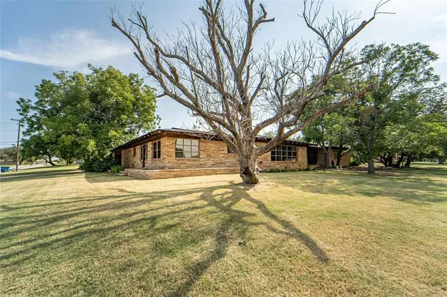 a yellow house with trees in front of it