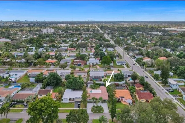 an aerial view of residential houses with outdoor space and trees