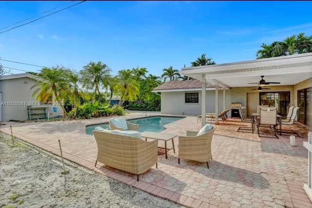 a view of a house with backyard and sitting area
