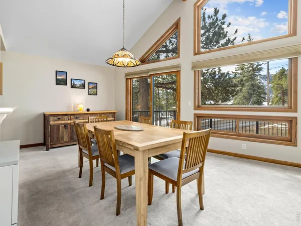 a view of a dining room with furniture a chandelier and wooden floor