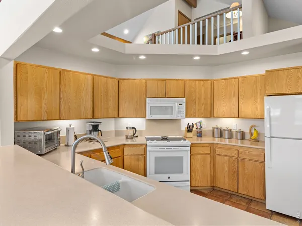 a kitchen with a sink a stove a refrigerator and cabinets