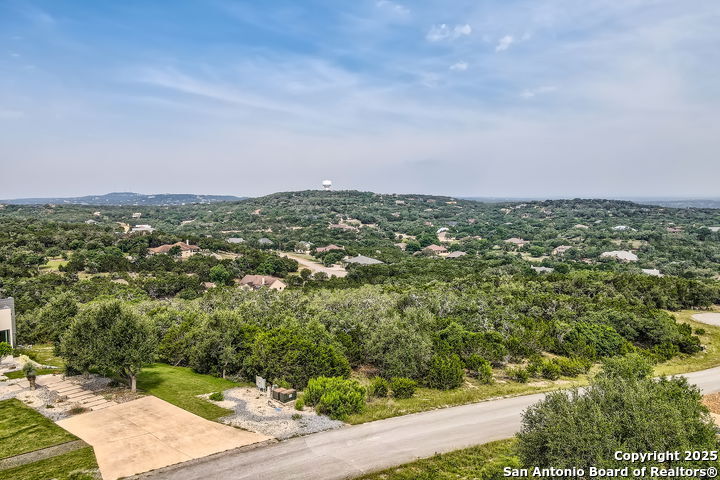 an aerial view of residential houses with outdoor space and trees