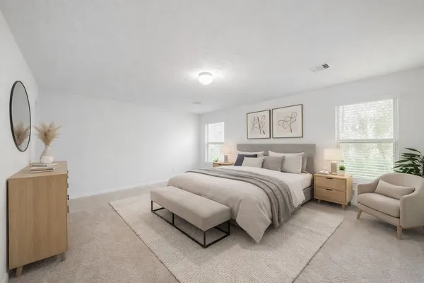 a spacious bedroom with a bed and a couch