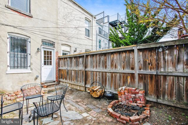 a backyard of a house with chairs and a potted plant