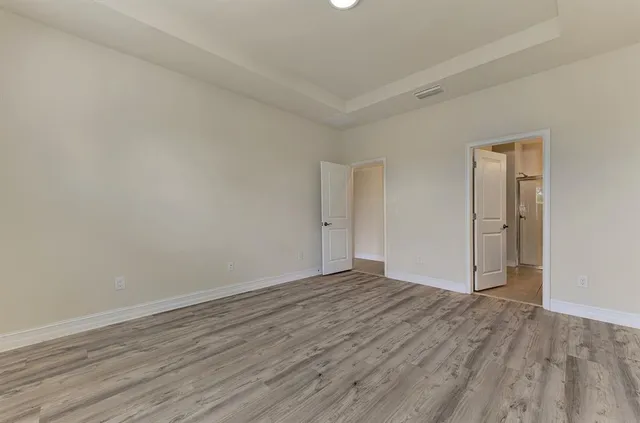 a view of an empty room with wooden floor