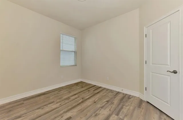 a view of a room with wooden floor and white walls
