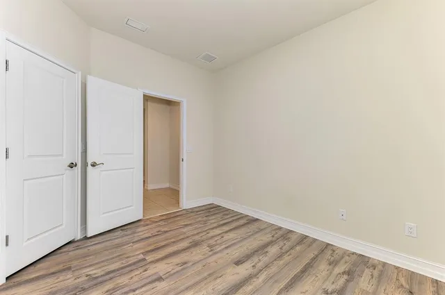 a view of an empty room with wooden floor