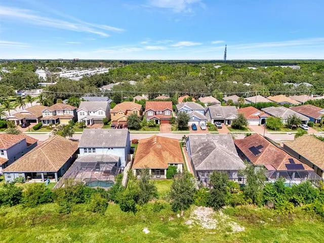 an aerial view of residential houses with outdoor space and trees