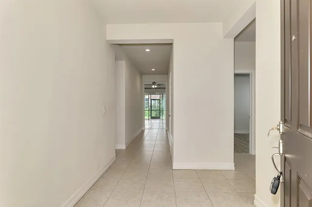 a view of a hallway with wooden floor and a bathroom