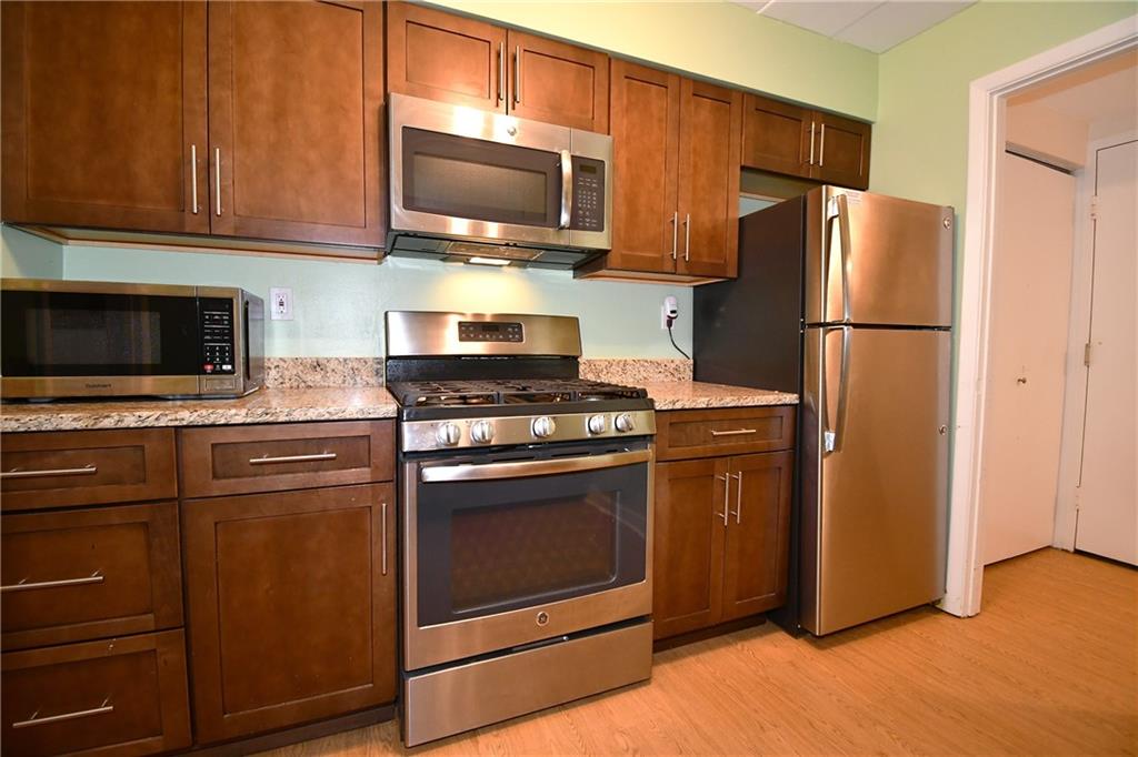 5 Bayard Road, Unit 100 Pittsburgh, PA 15213 - Photo 11 of 30 a kitchen with granite countertop a refrigerator stove and microwave