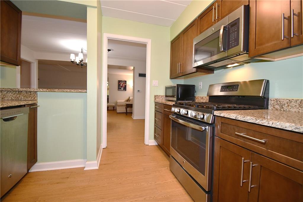 5 Bayard Road, Unit 100 Pittsburgh, PA 15213 - Photo 9 of 30 a kitchen with stainless steel appliances granite countertop a refrigerator and a stove top oven