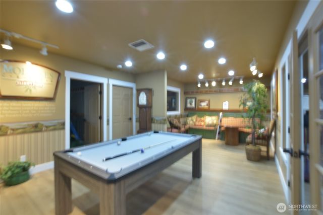 a room with pool table and glass windows
