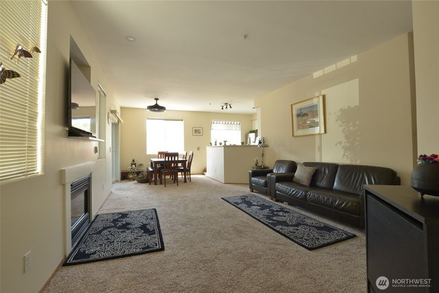 a living room with furniture and a dining table with kitchen view