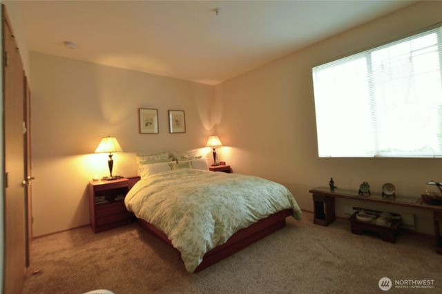a bedroom with a bed and a lamp next to a window