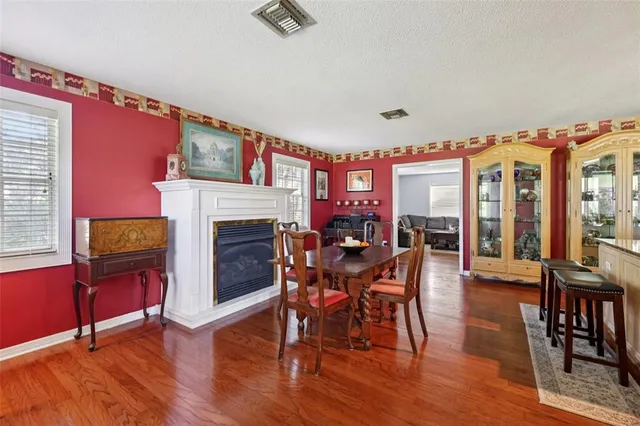 a dining room with furniture a floor to ceiling window and wooden floor