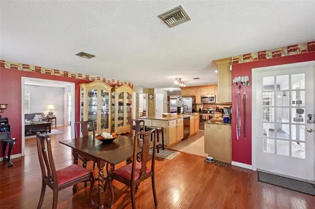 a view of a dining room with furniture wooden floor and chandelier