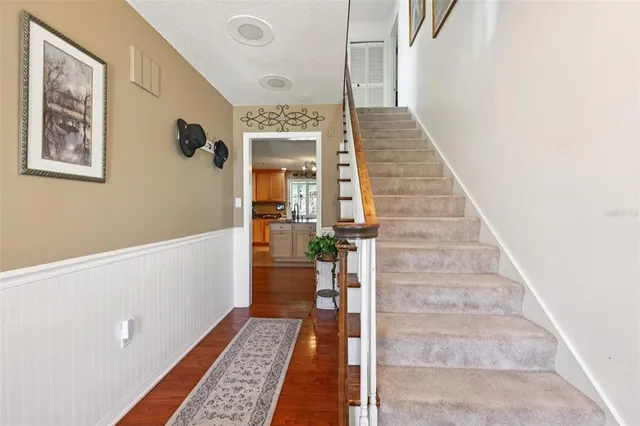 a view of a hallway with wooden floor and staircase