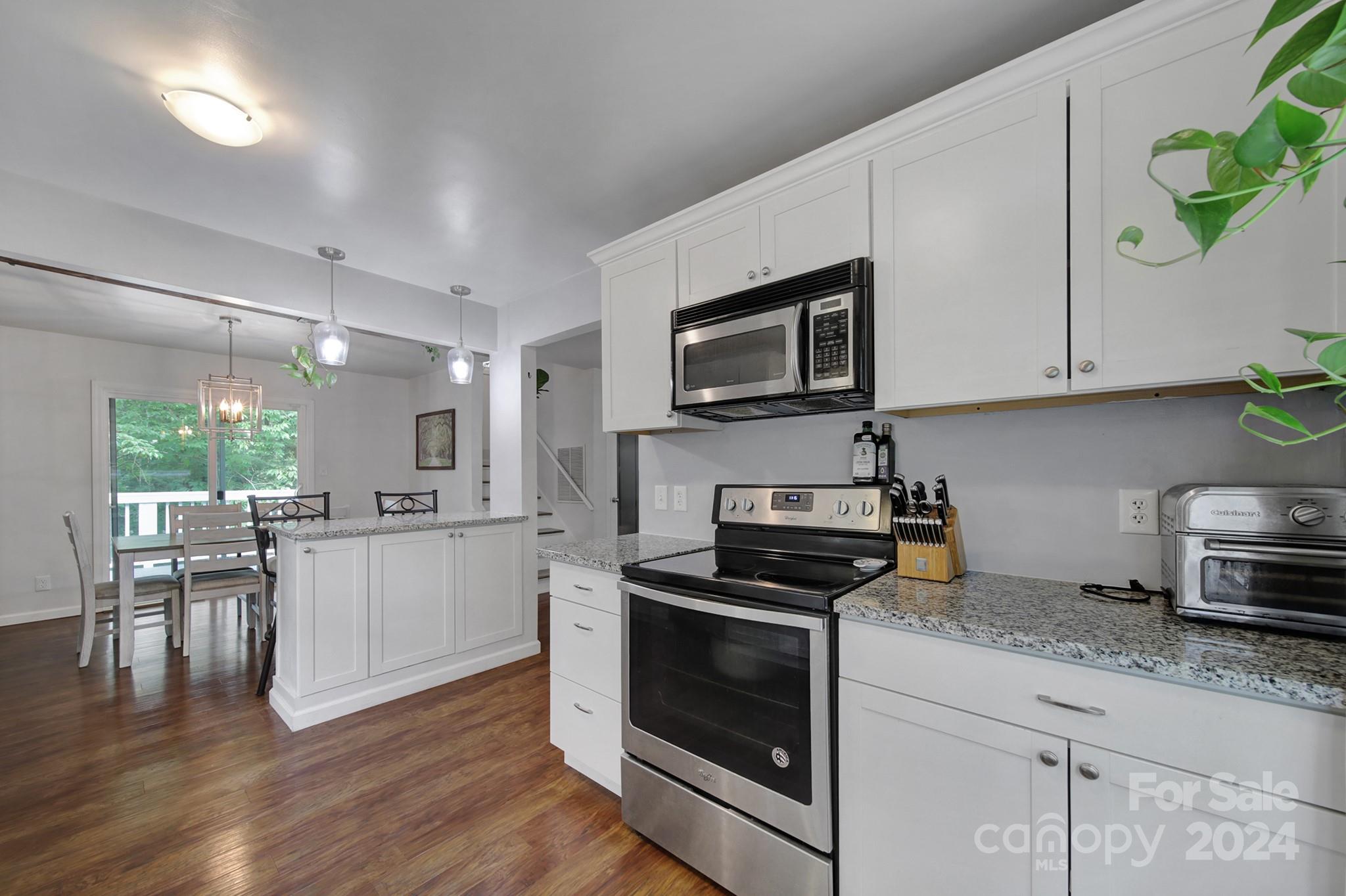 6027 Windjammer Drive Tega Cay, SC 29708 - Photo 11 of 27 a kitchen with granite countertop appliances cabinets and a wooden floor