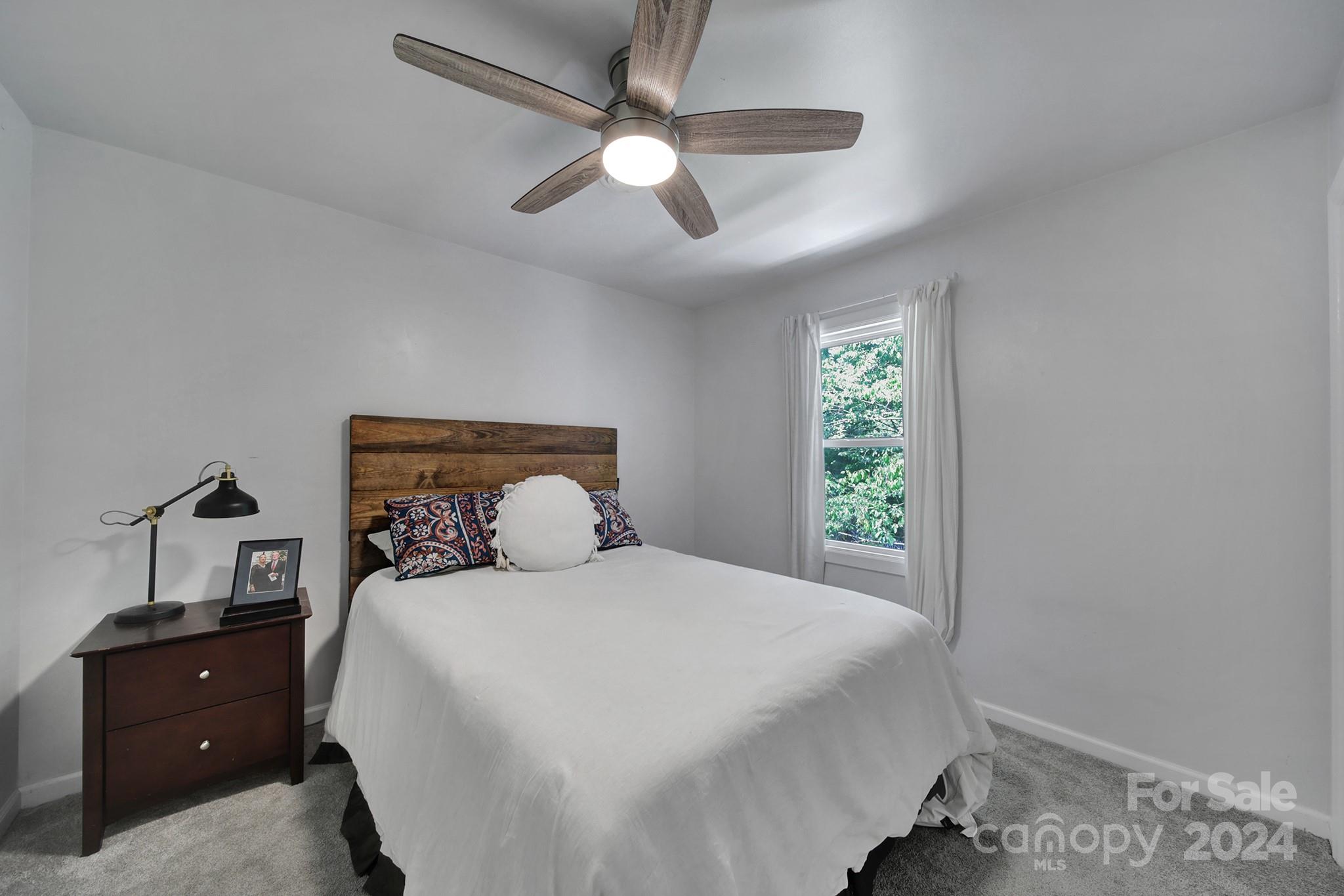 6027 Windjammer Drive Tega Cay, SC 29708 - Photo 15 of 27 a bedroom with a large bed and a window