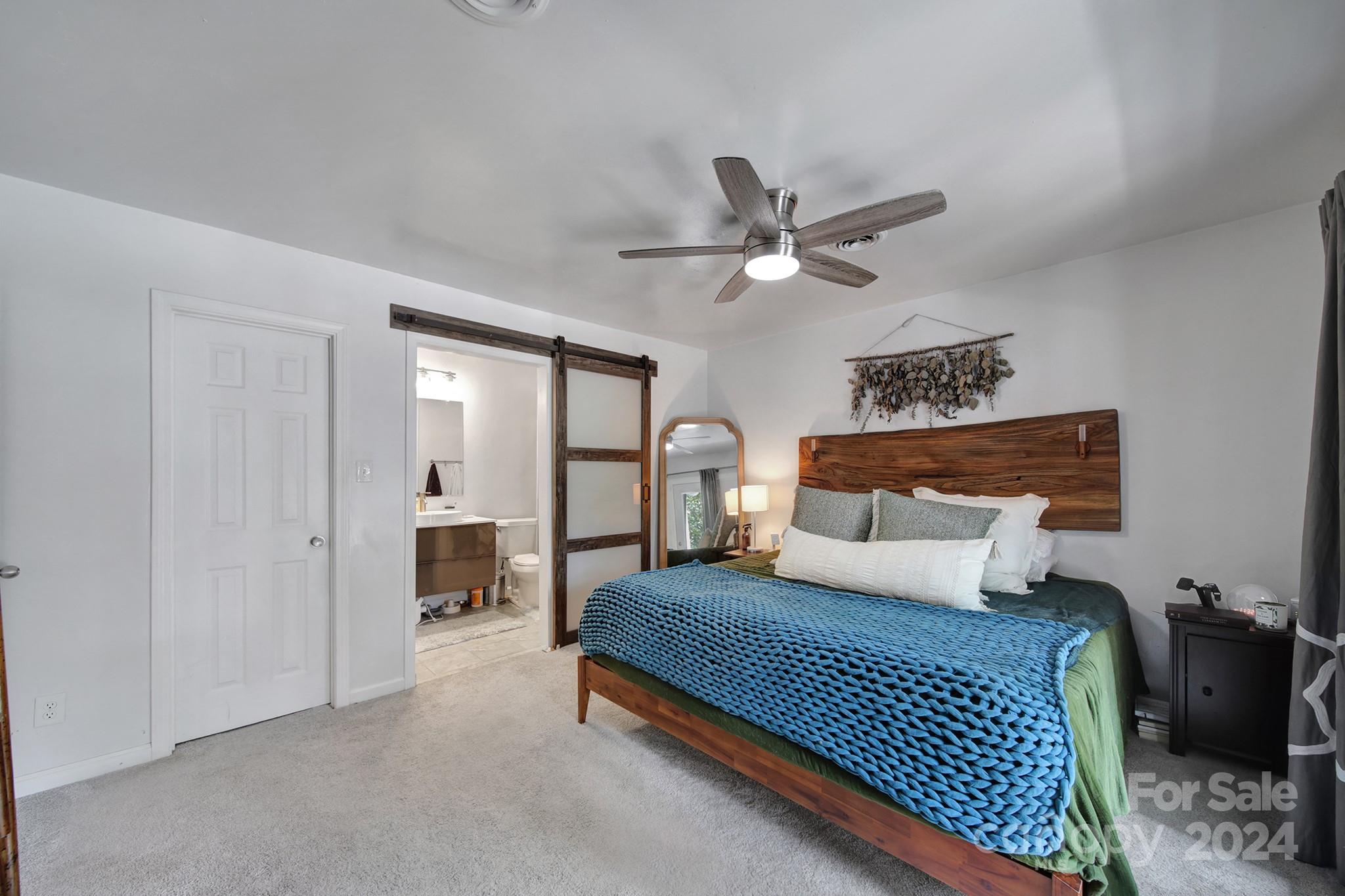 6027 Windjammer Drive Tega Cay, SC 29708 - Photo 19 of 27 a bedroom with a large bed a chandelier and dresser