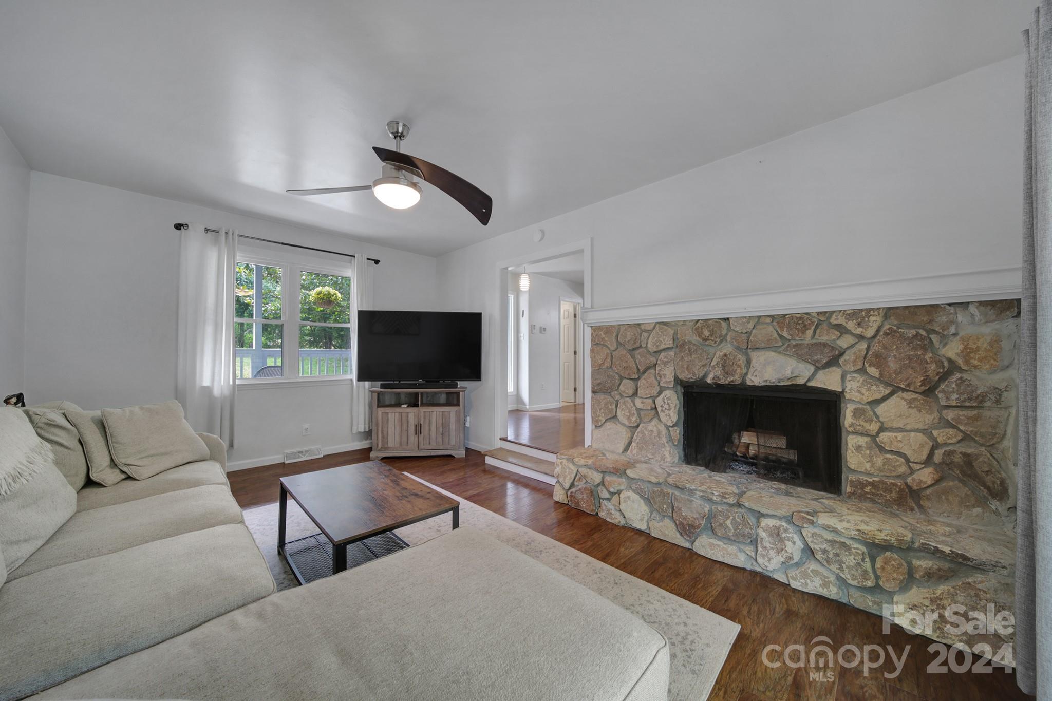 6027 Windjammer Drive Tega Cay, SC 29708 - Photo 7 of 27 a living room with furniture a flat screen tv and a fireplace