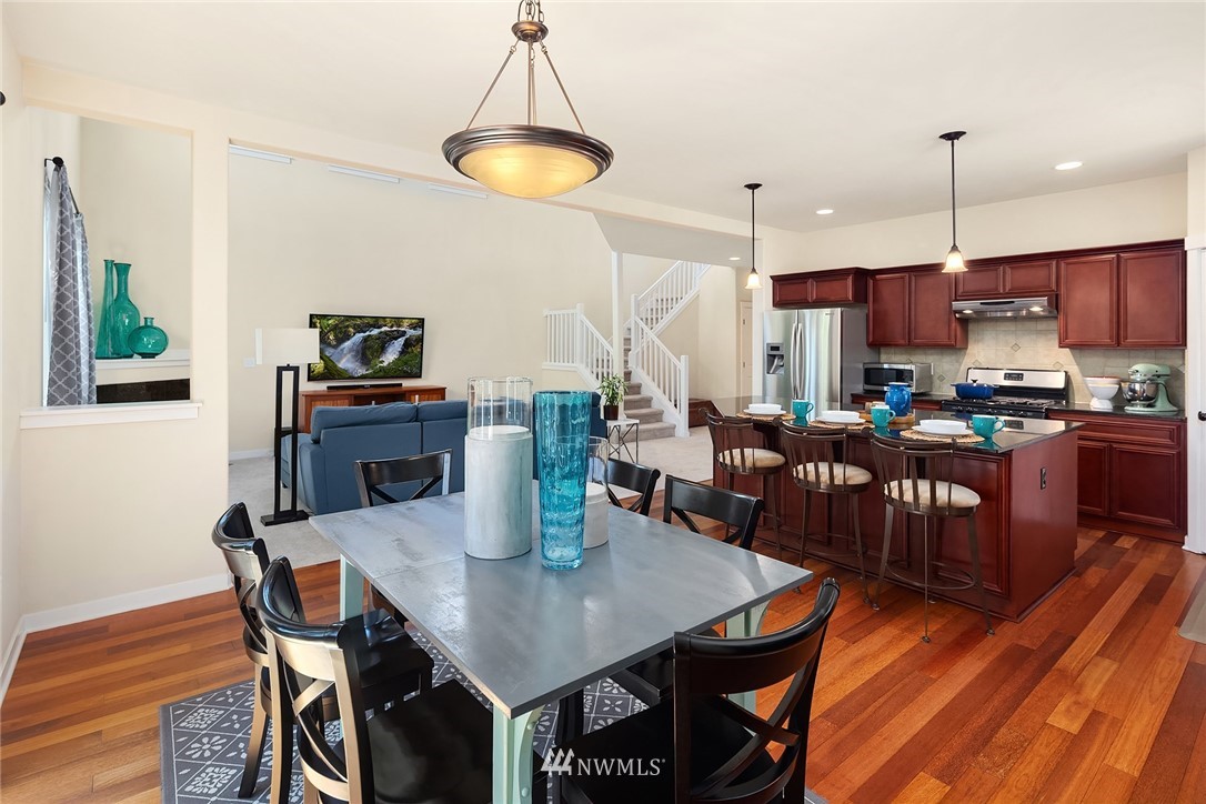 5115 Northeast 6th Place Renton, WA 98059 - Photo 12 of 26 a view of a dining room with furniture a chandelier and wooden floor