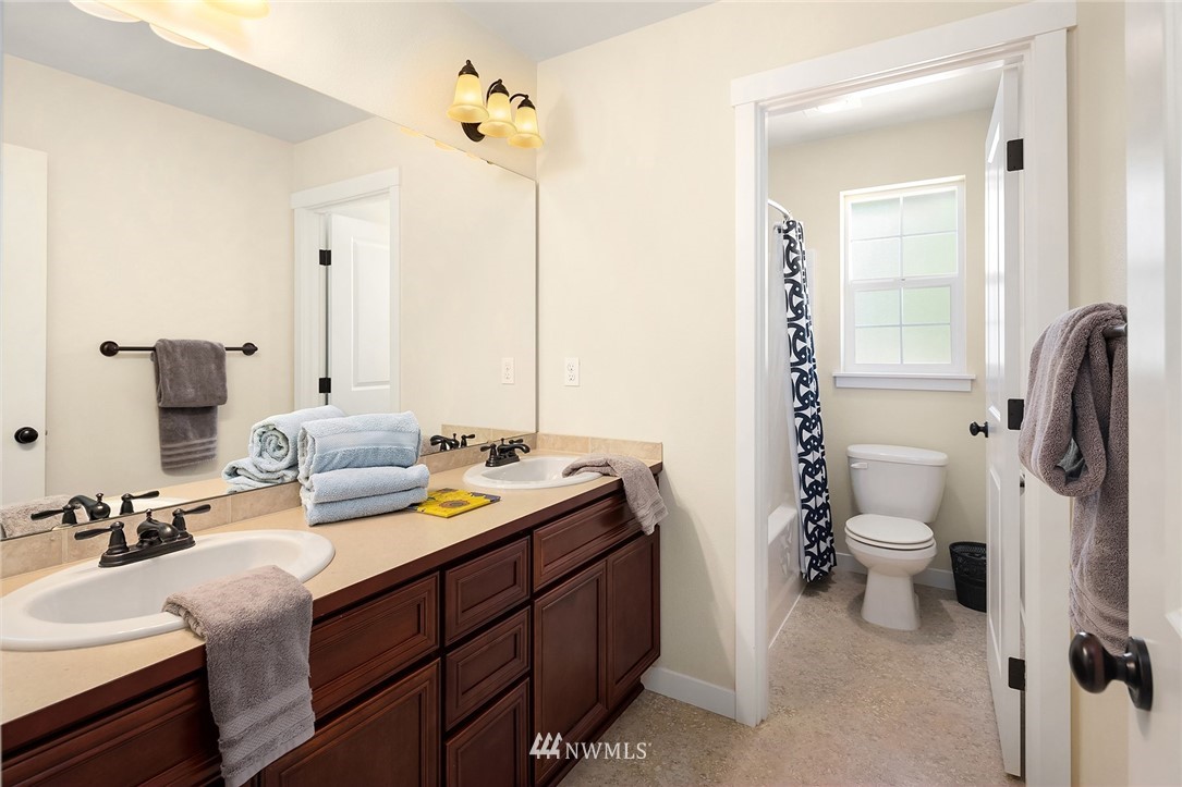 5115 Northeast 6th Place Renton, WA 98059 - Photo 15 of 26 a bathroom with a double vanity sink toilet and mirror