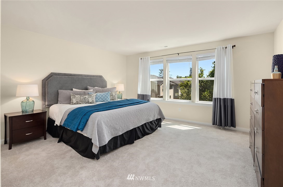 5115 Northeast 6th Place Renton, WA 98059 - Photo 17 of 26 a spacious bedroom with a bed lamp and a large window