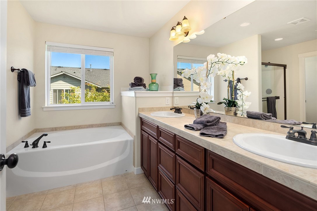 5115 Northeast 6th Place Renton, WA 98059 - Photo 20 of 26 a bathroom with a tub a sink double vanity and a mirror