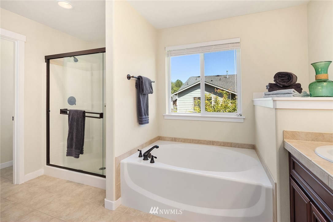 5115 Northeast 6th Place Renton, WA 98059 - Photo 21 of 26 a bathroom with a tub a sink and a shower