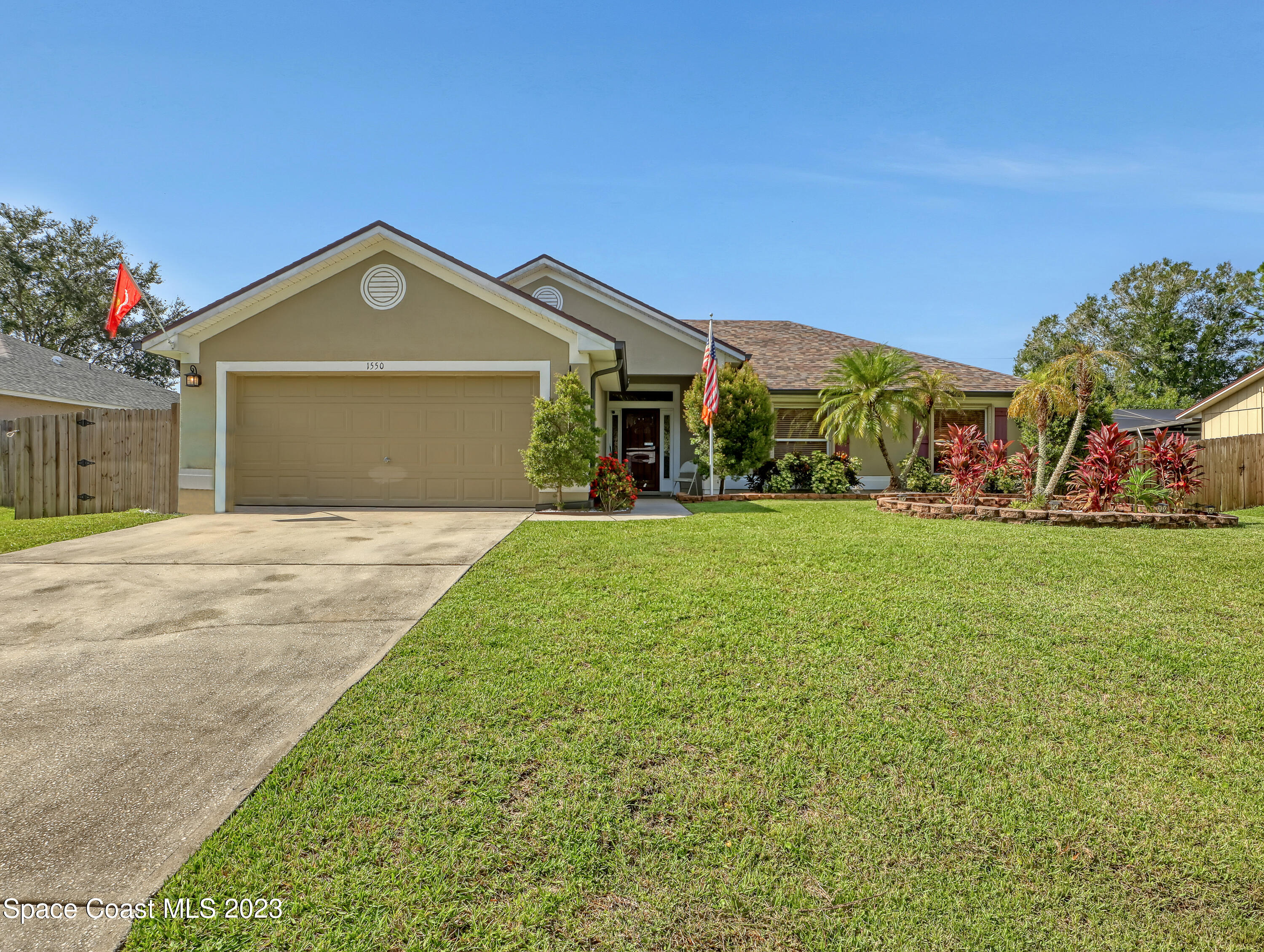 1550 Reed Street Northwest Palm Bay, FL 32907 - Photo 1 of 33 a front view of a house with a yard and garage