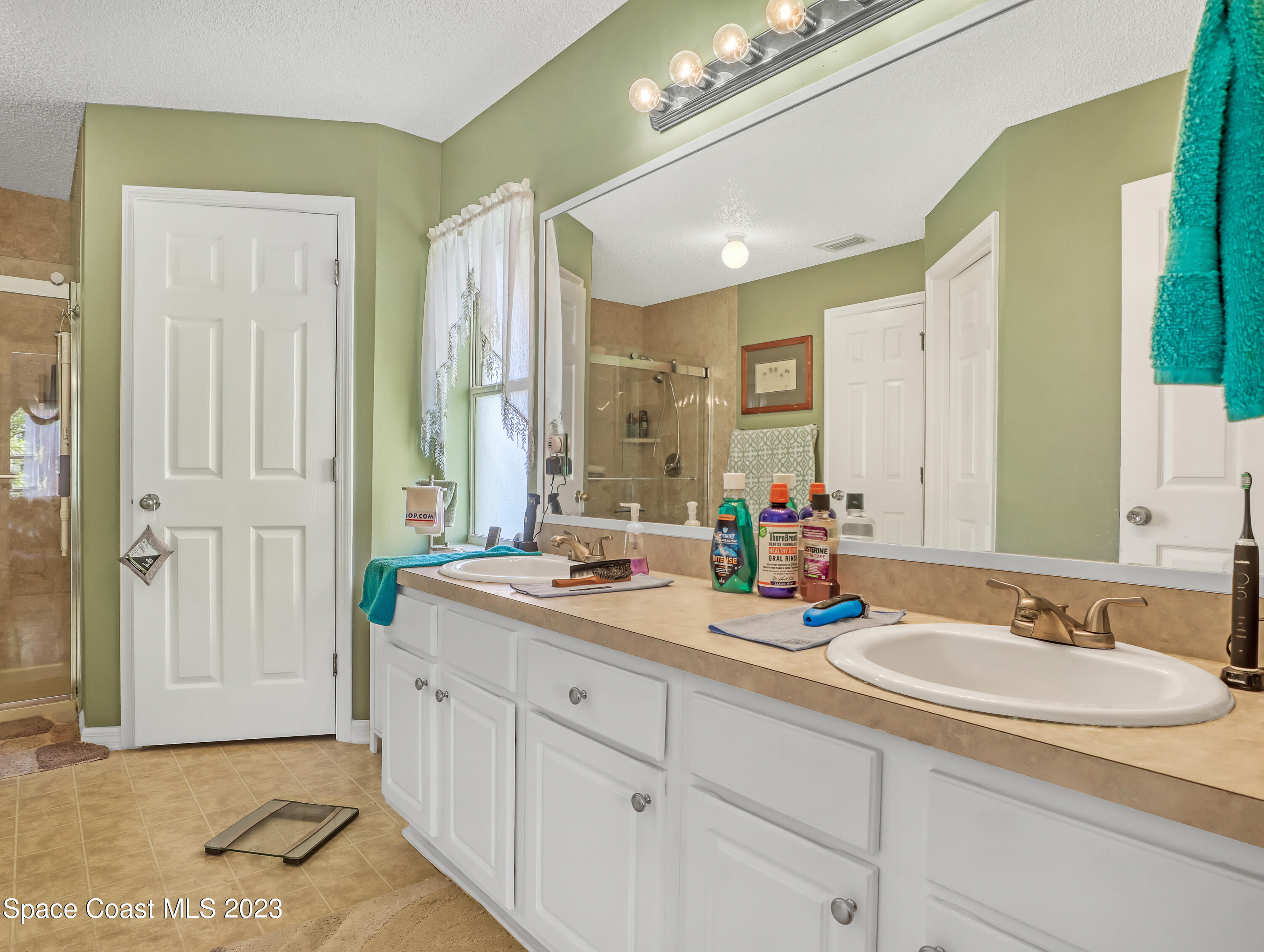 1550 Reed Street Northwest Palm Bay, FL 32907 - Photo 19 of 33 a bathroom with double sink and a mirror