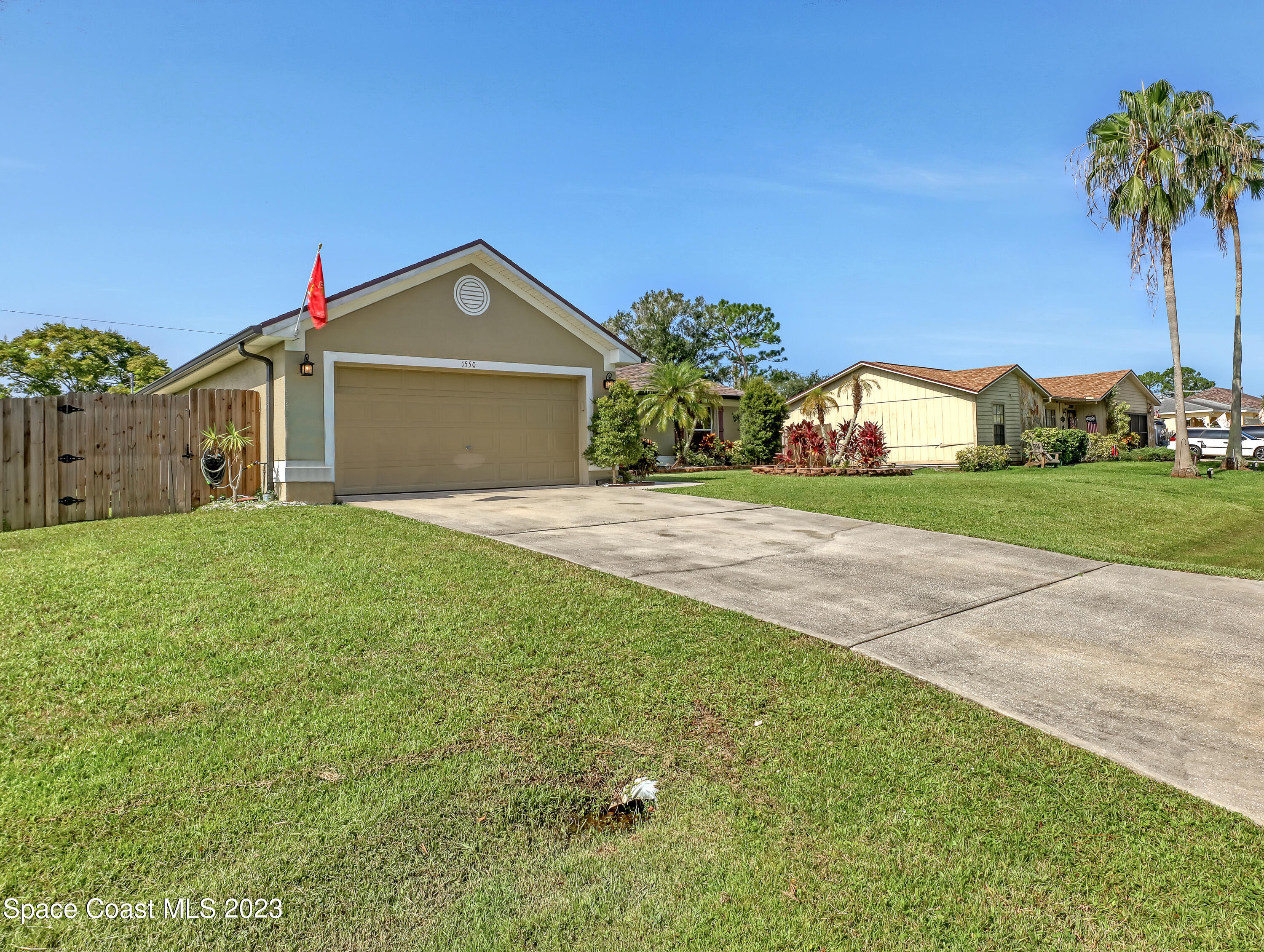 1550 Reed Street Northwest Palm Bay, FL 32907 - Photo 2 of 33 a front view of a house with a yard and garage