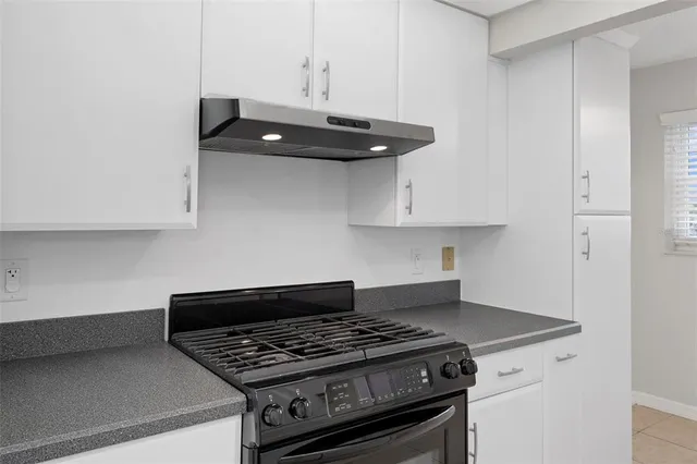 a stove top oven sitting inside of a kitchen