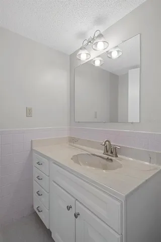 a bathroom with a sink a light fixture and a mirror