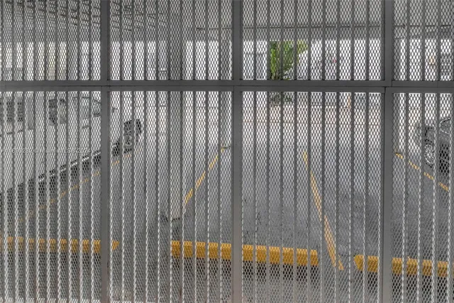 a view of a building with a yard and fountain in the background