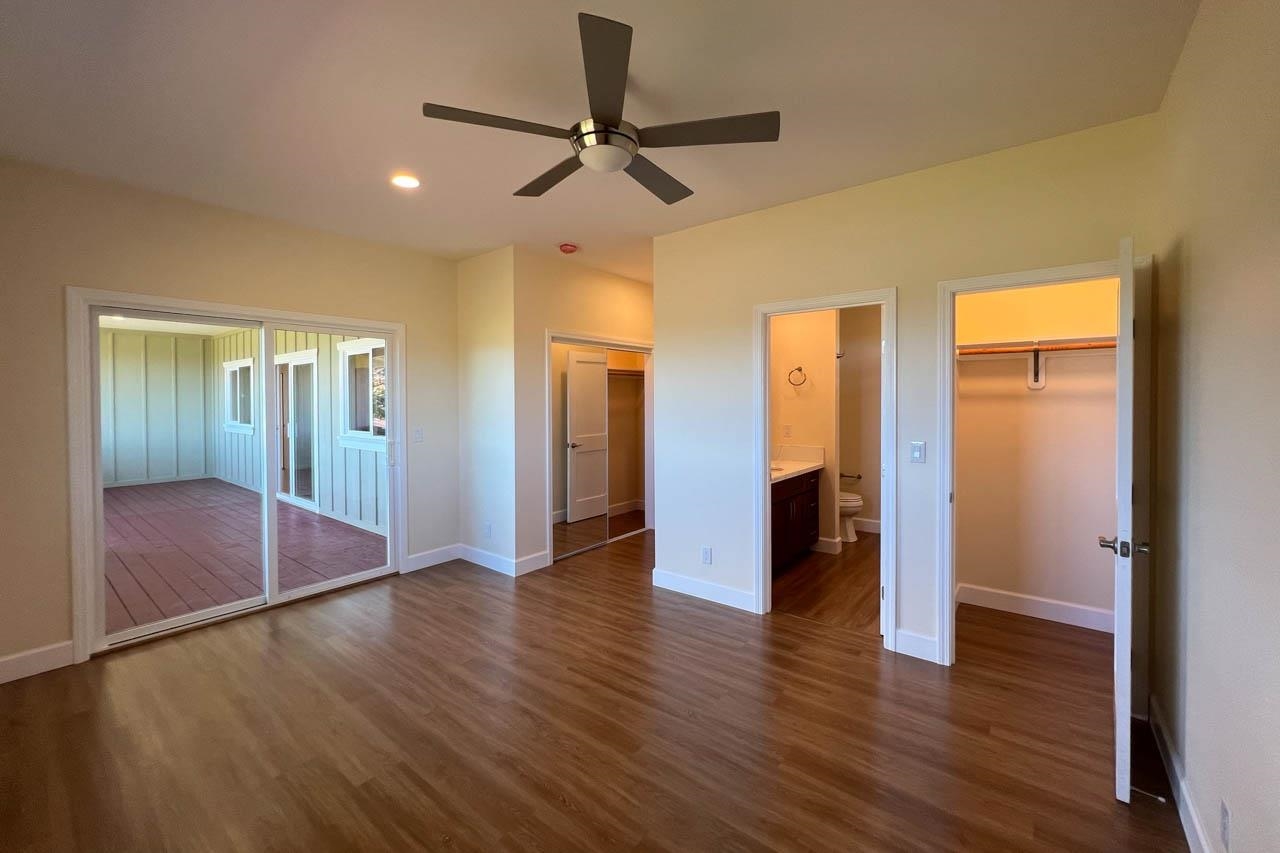 2728 Kaupakalua Road, Unit B Haiku, HI 96708 - Photo 14 of 29 a view of a livingroom with wooden floor and a ceiling fan