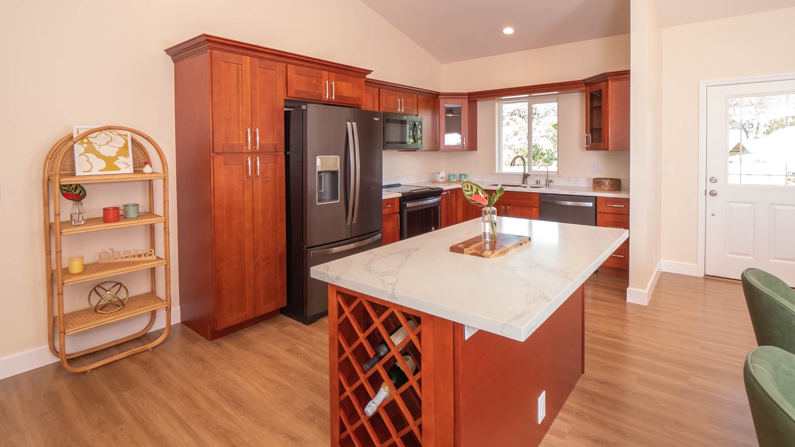 2728 Kaupakalua Road, Unit B Haiku, HI 96708 - Photo 7 of 29 a kitchen with stainless steel appliances a dining table a refrigerator and wooden cabinets
