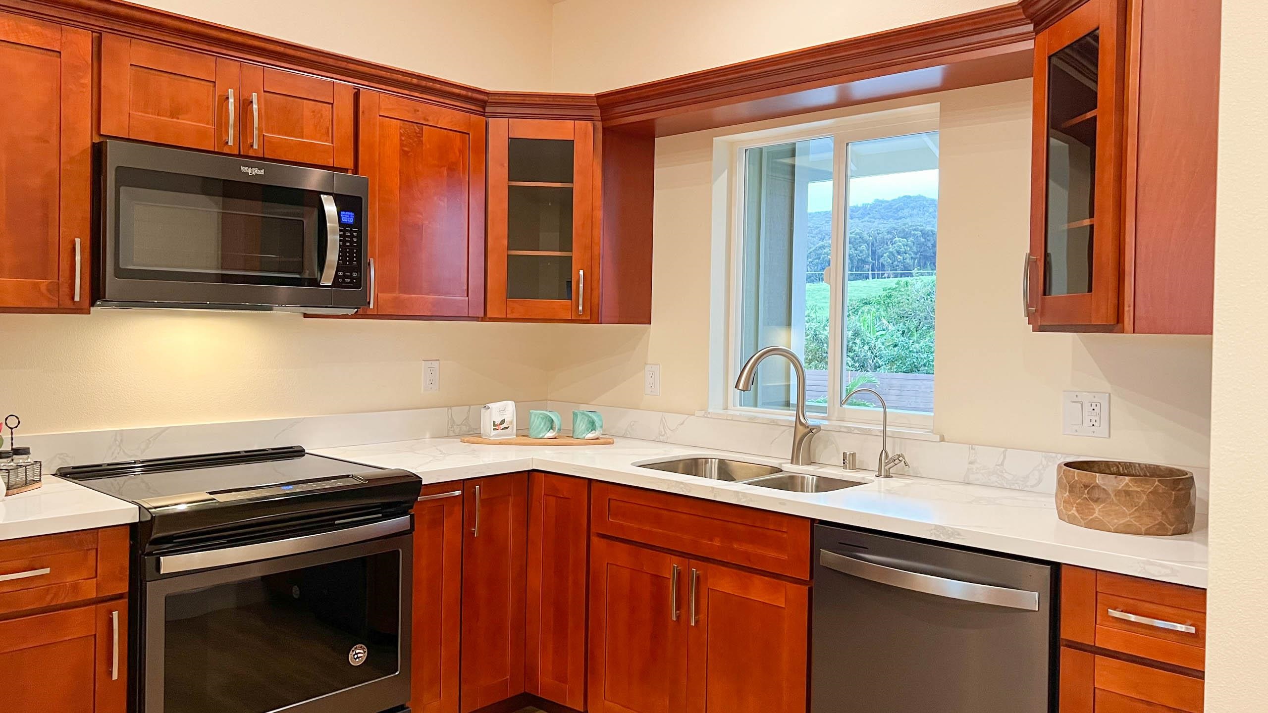 2728 Kaupakalua Road, Unit B Haiku, HI 96708 - Photo 9 of 29 a kitchen with stainless steel appliances a stove microwave and sink