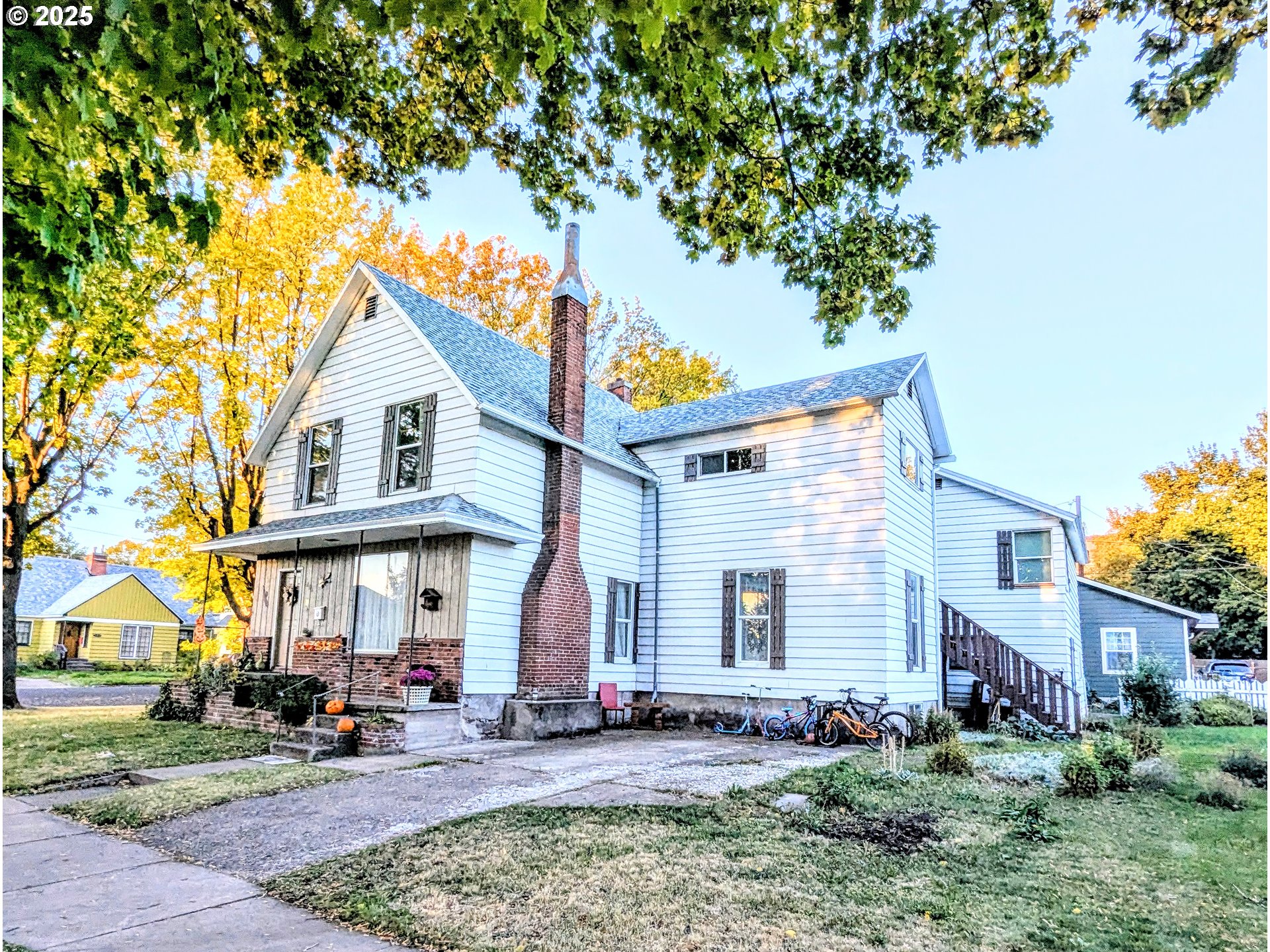 1802 3rd Street La Grande, OR 97850 - Photo 1 of 21 a view of a white house with large windows and a small yard