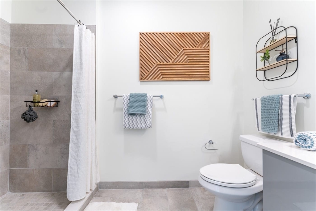 346 Somerville Avenue, Unit 304 Somerville, MA 02143 - Photo 5 of 10 a bathroom with a toilet a sink and mirror