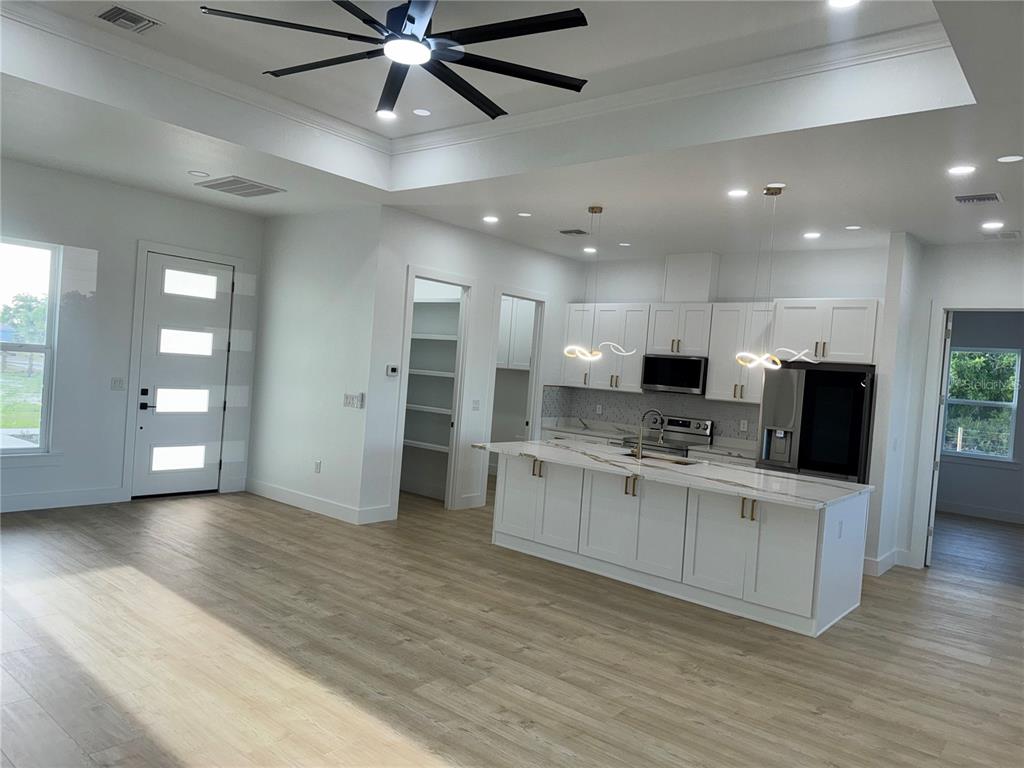 1721 McClellan Road Frostproof, FL 33843 - Photo 18 of 41 a view of kitchen with stainless steel appliances kitchen island a sink dishwasher a refrigerator and a fireplace